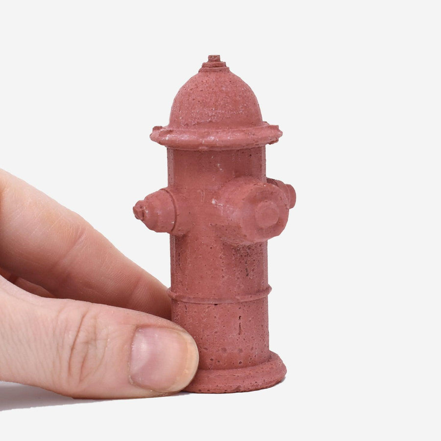 1:12 scale miniature red-dyed concrete fire hydrant being held by a hand to show scale.